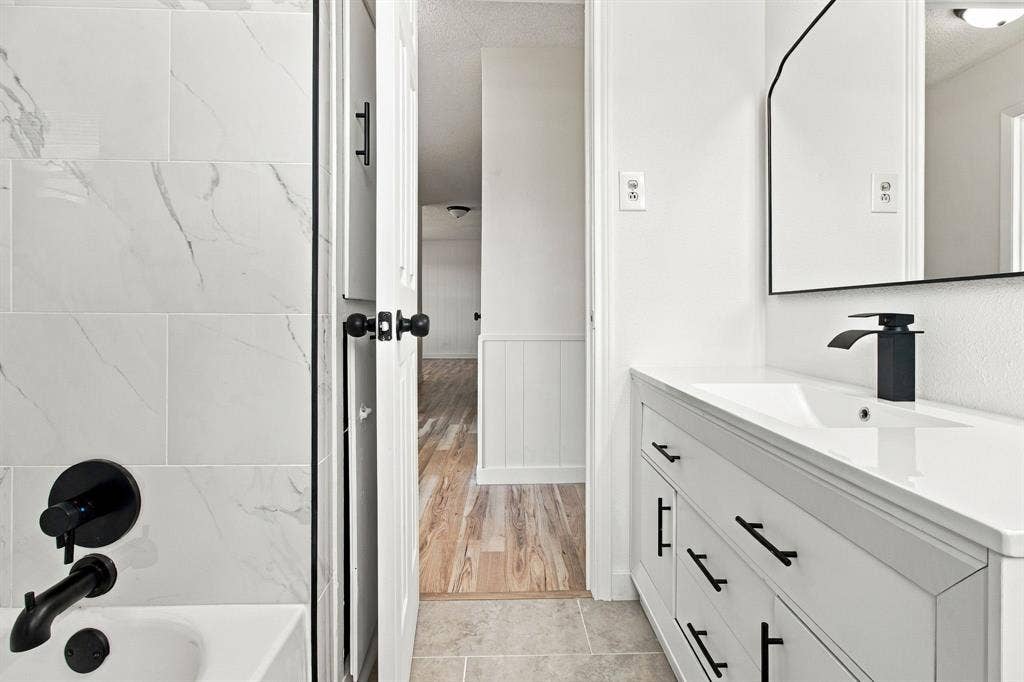White vanity with integrated sink and matte black faucet