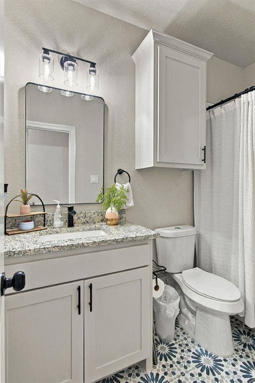 4822 Wichita Street, Granbury, TX 76048 Vanity with a granite-style countertop, undermount sink, and matte black faucet