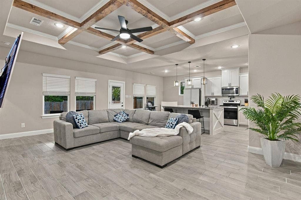 4822 Wichita Street, Granbury, TX 76048 Coffered ceiling with exposed wood beams, recessed lighting, wood-finish flooring, white cabinetry, and stainless steel appliances