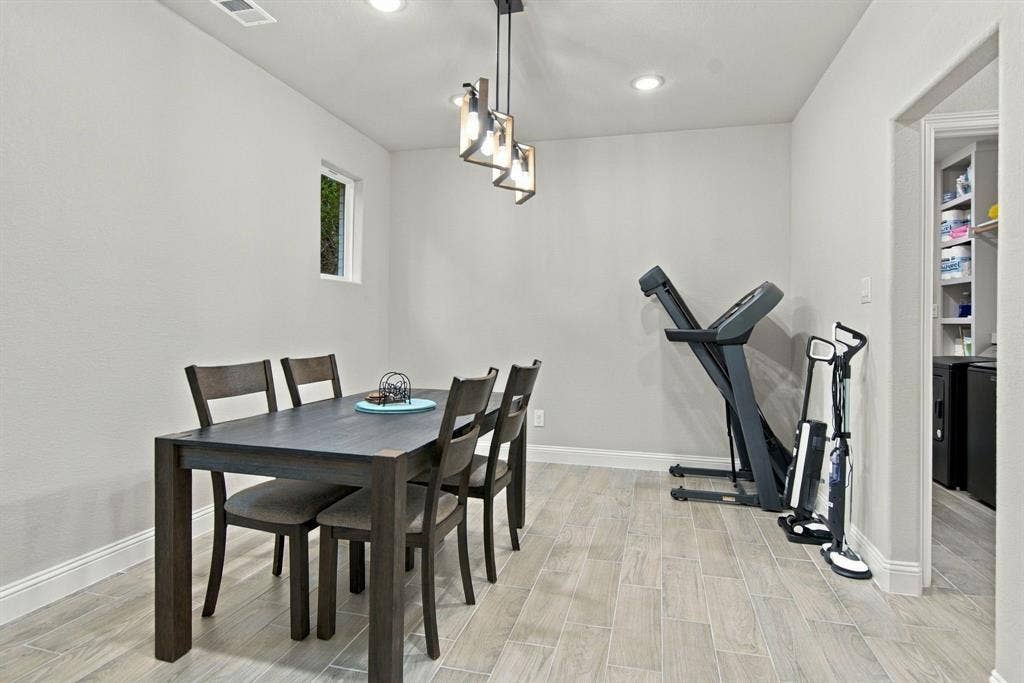 4822 Wichita Street, Granbury, TX 76048 Recessed lighting with a contemporary chandelier, light-toned walls, and wood-finish flooring