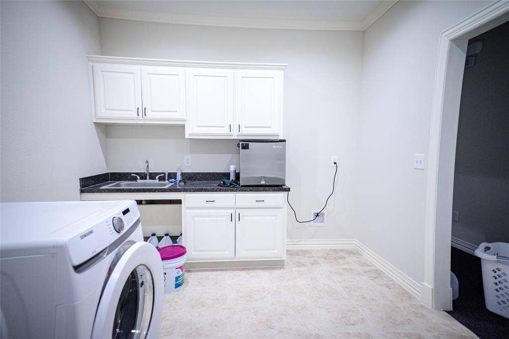 8668 John Hickman Parkway, #906, Frisco, TX 75034 White cabinetry with dark hardware, dark countertop with an undermount sink, and tiled flooring