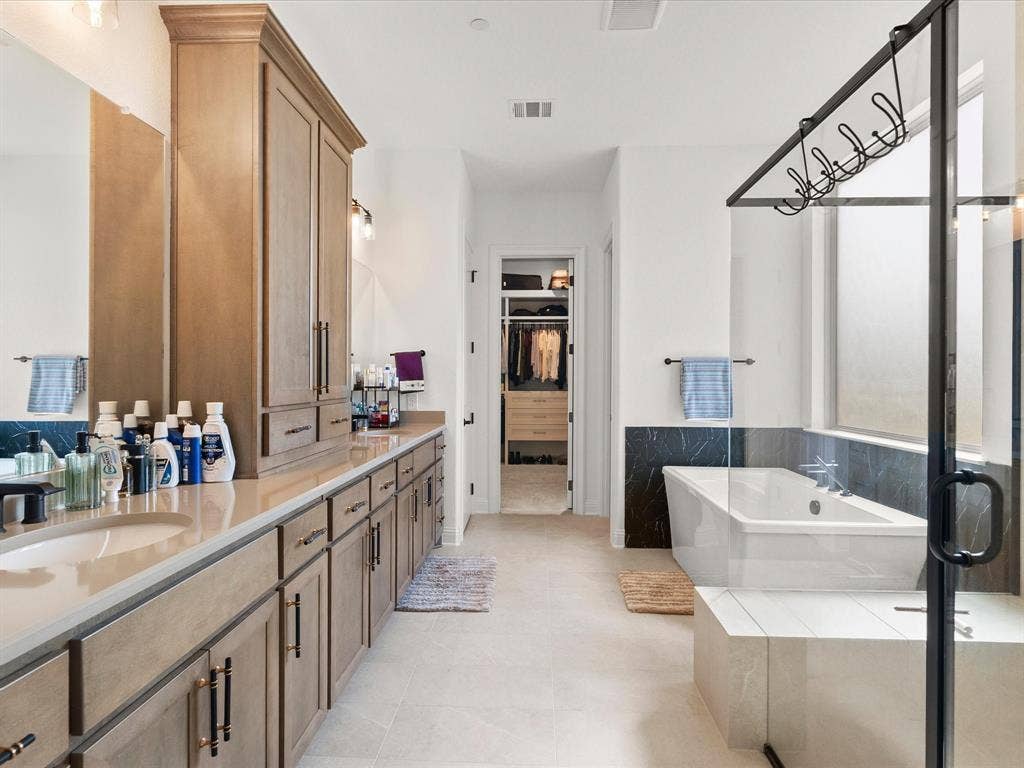 1020 Williams Lane, Copper Canyon, TX 75077 Spacious primary bathroom downstairs. Large double vanity, beautiful cabinets, large walk in shower and large tub upgraded stone countertops.