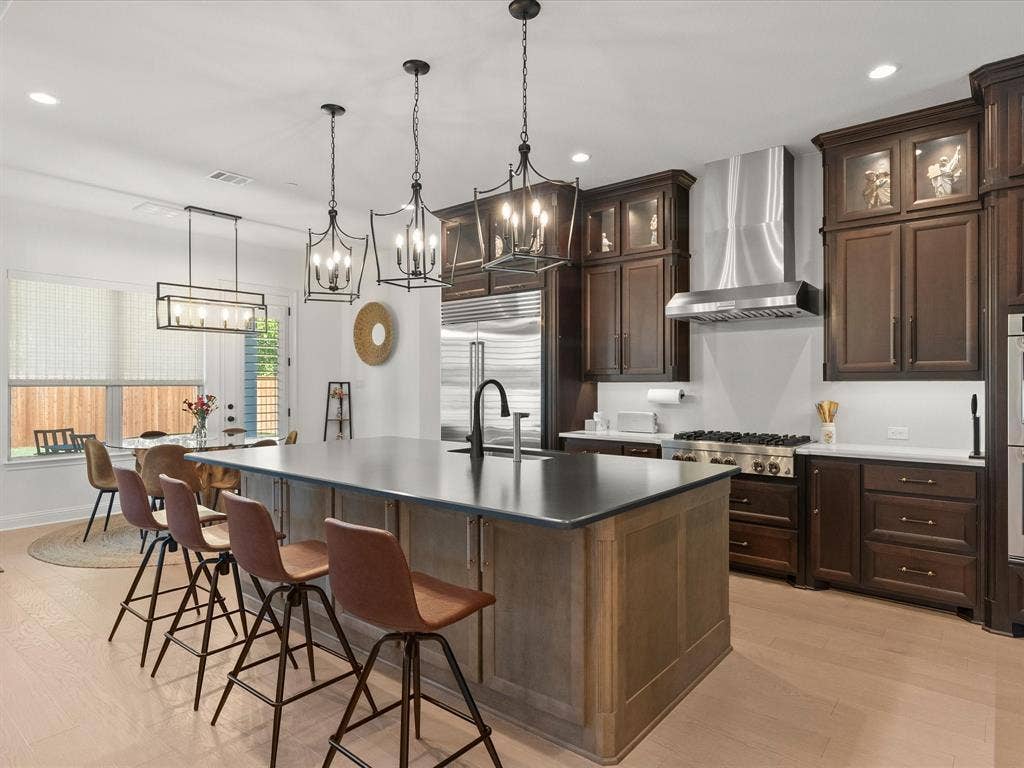 1020 Williams Lane, Copper Canyon, TX 75077 Spacious kitchen with stainless steel appliances built in refrigerator large walk in panty , breakfast nook, Cortez countertops, gorgeous light fixtures over the bar and breakfast nook. Upgraded cabinets with glass, double ovens, and osmosis added.