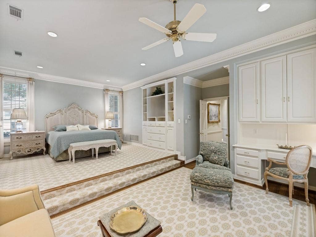 Raised sleeping area with recessed lighting, crown molding, built-in cabinetry, ceiling fan, and dedicated desk space