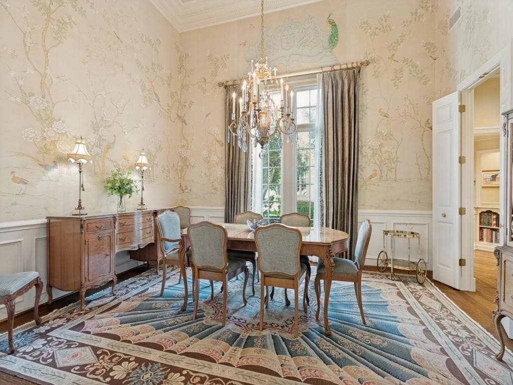 Hardwood flooring, decorative wall paneling, intricate wall coverings, high ceilings, and an elegant chandelier