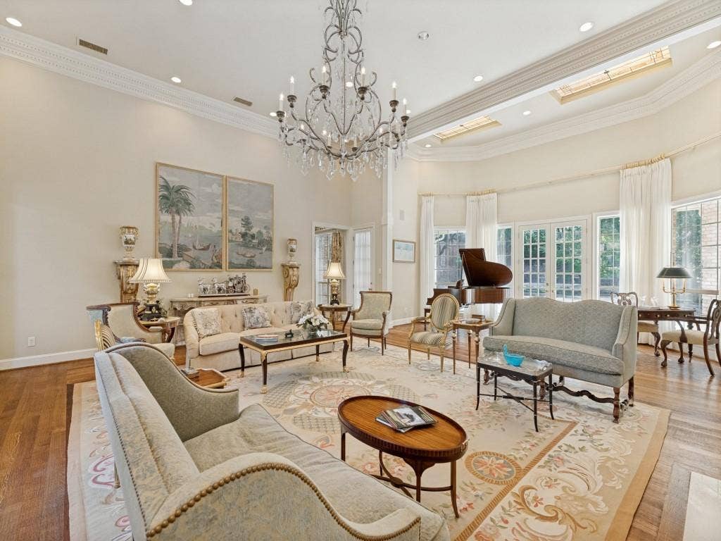Hardwood flooring, high ceilings with crown molding, recessed lighting, chandelier lighting, and multiple French doors
