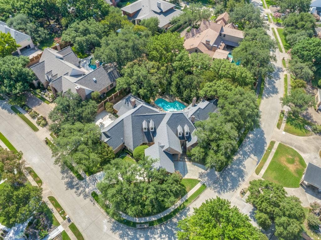 Spacious property featuring a multi-gabled roofline, multiple dormer windows, and a paved driveway
