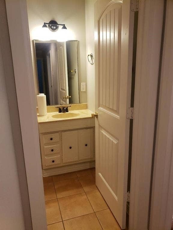 3602 Palm Drive, Mesquite, TX 75150 Vanity with a single basin, wall-mounted light fixture, and tile flooring