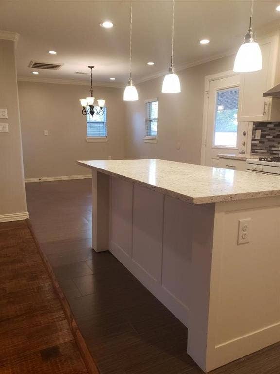 3602 Palm Drive, Mesquite, TX 75150 Modern kitchen featuring a substantial island with a light stone countertop, pendant lighting with frosted glass shades, recessed ceiling lights, and stainless steel appliances