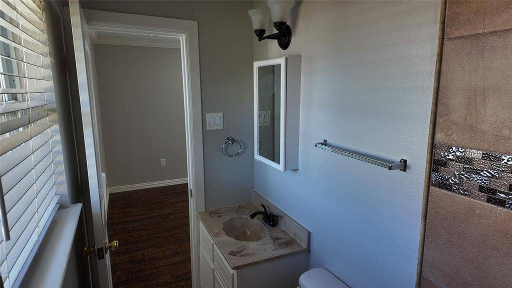 3602 Palm Drive, Mesquite, TX 75150 Vanity with integrated sink, wall-mounted light fixture, and medicine cabinet
