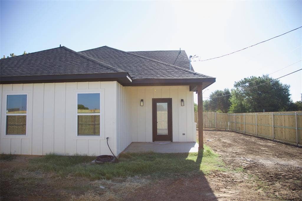 9432 PRAIRIEVIEW Drive, Crowley, TX 76134 Board and batten siding, dark-shingle roof, covered patio with support column, fenced yard, and exterior lighting fixtures