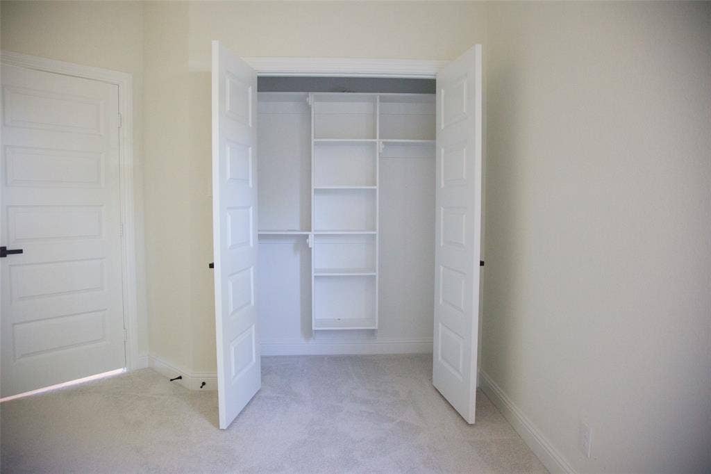 9432 PRAIRIEVIEW Drive, Crowley, TX 76134 Built-in closet shelving, integrated hanging rods, panel doors, and neutral wall color