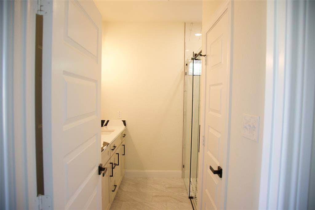 9432 PRAIRIEVIEW Drive, Crowley, TX 76134 White panel doors with dark hardware, a vanity with a white countertop, and glass shower enclosure