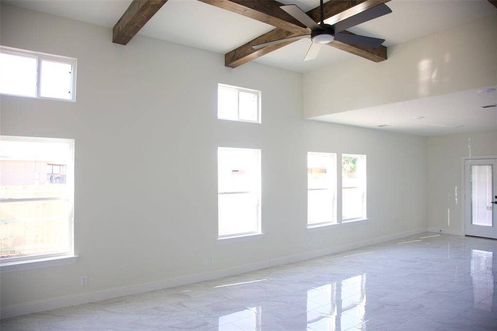 9432 PRAIRIEVIEW Drive, Crowley, TX 76134 Vaulted ceiling with exposed wood beams, high windows, white walls, and a multi-blade ceiling fan