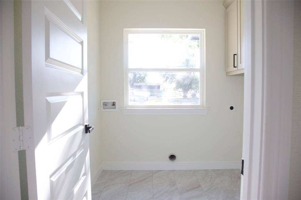 9432 PRAIRIEVIEW Drive, Crowley, TX 76134 Recessed window with white trim, upper cabinetry featuring black hardware, white paneled door with black hardware, and tiled flooring