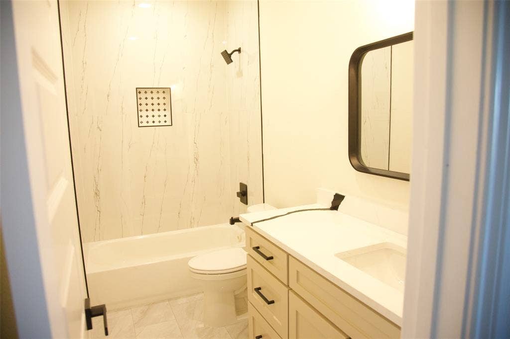 9432 PRAIRIEVIEW Drive, Crowley, TX 76134 Bathroom featuring a built-in tub with a shower, white paneled surround, and a recessed shower niche