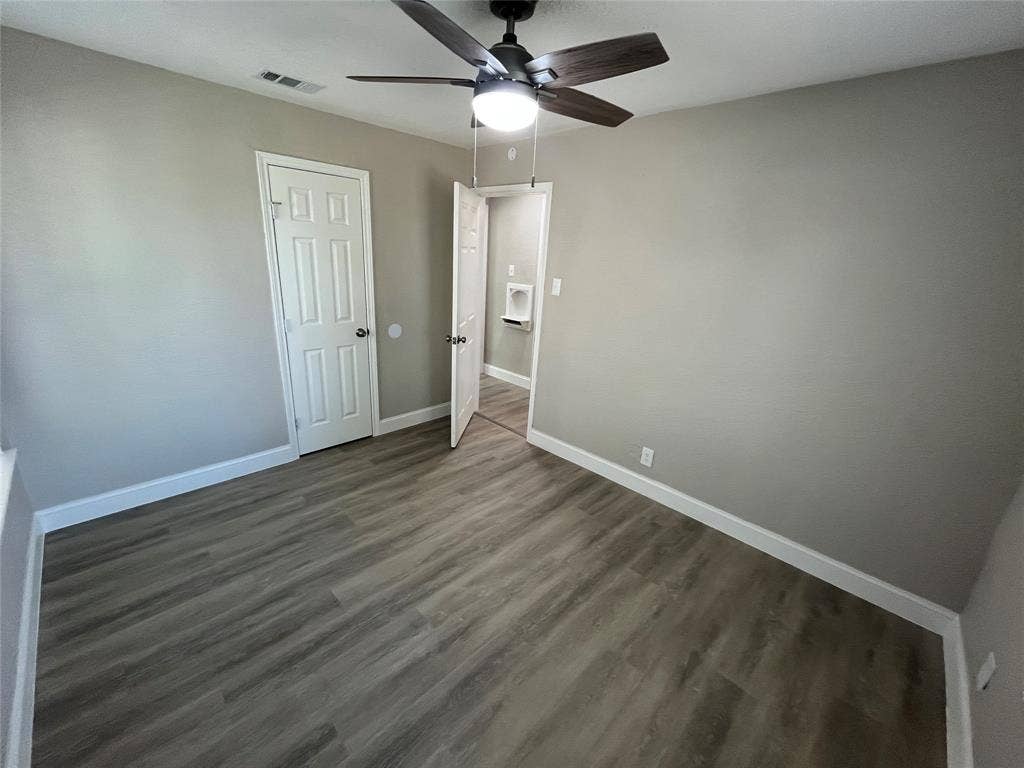 622 Austin Street, Grand Prairie, TX 75051 Wood-finish flooring, neutral wall tones, multi-panel doors, and a ceiling fan with integrated lighting fixture