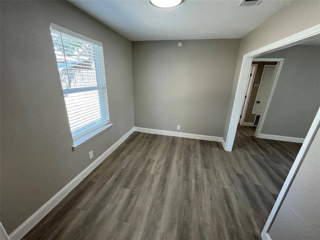 622 Austin Street, Grand Prairie, TX 75051 Room featuring neutral wall paint, wood-finish flooring, and a window with blinds