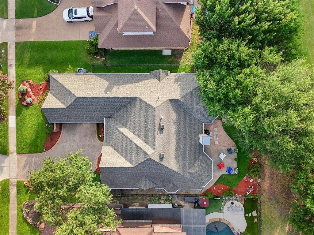 521 Palm Desert Drive, Garland, TX 75044 Gabled roofline, concrete driveway, front yard landscaping, rear patio with paved hardscaping, and a swimming pool