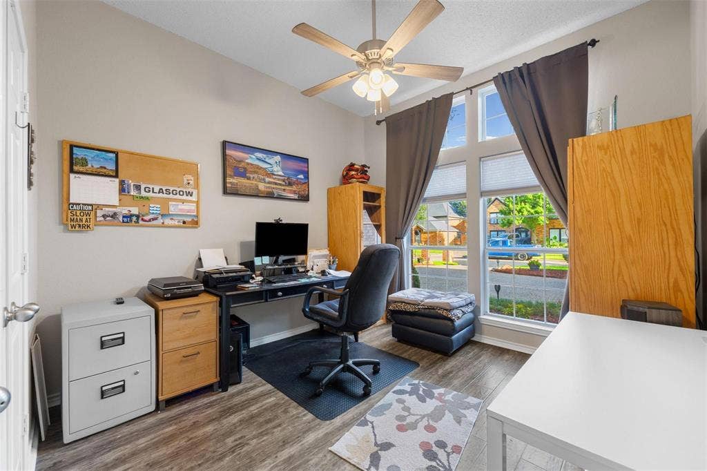 521 Palm Desert Drive, Garland, TX 75044 Wood-finish flooring, ceiling fan with integrated lighting, and multiple windows providing ample natural illumination