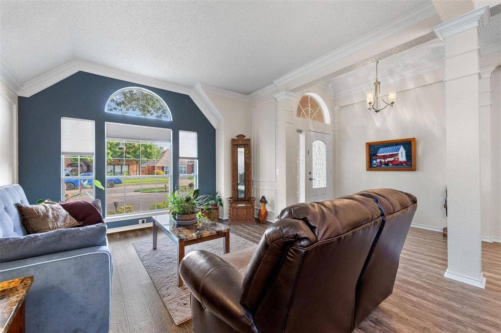 521 Palm Desert Drive, Garland, TX 75044 Vaulted ceilings, wood-finish flooring, decorative entryway with arched transom, and a large picture window with an arched transom