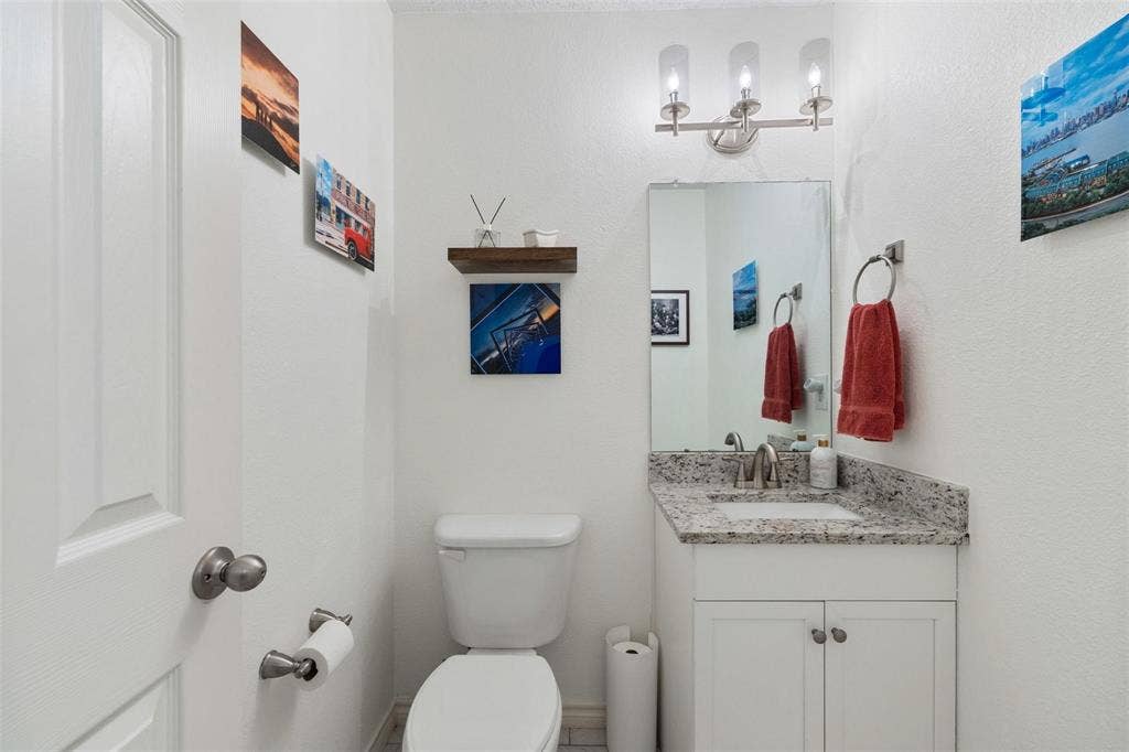 521 Palm Desert Drive, Garland, TX 75044 Vanity with a granite countertop and an undermount sink, illuminated by a three-light fixture