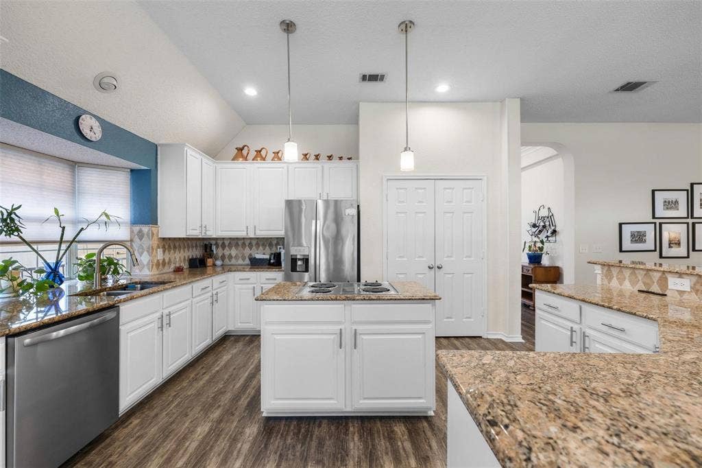 521 Palm Desert Drive, Garland, TX 75044 Kitchen featuring white cabinetry, granite countertops, stainless steel appliances, a center island, and wood-finish flooring