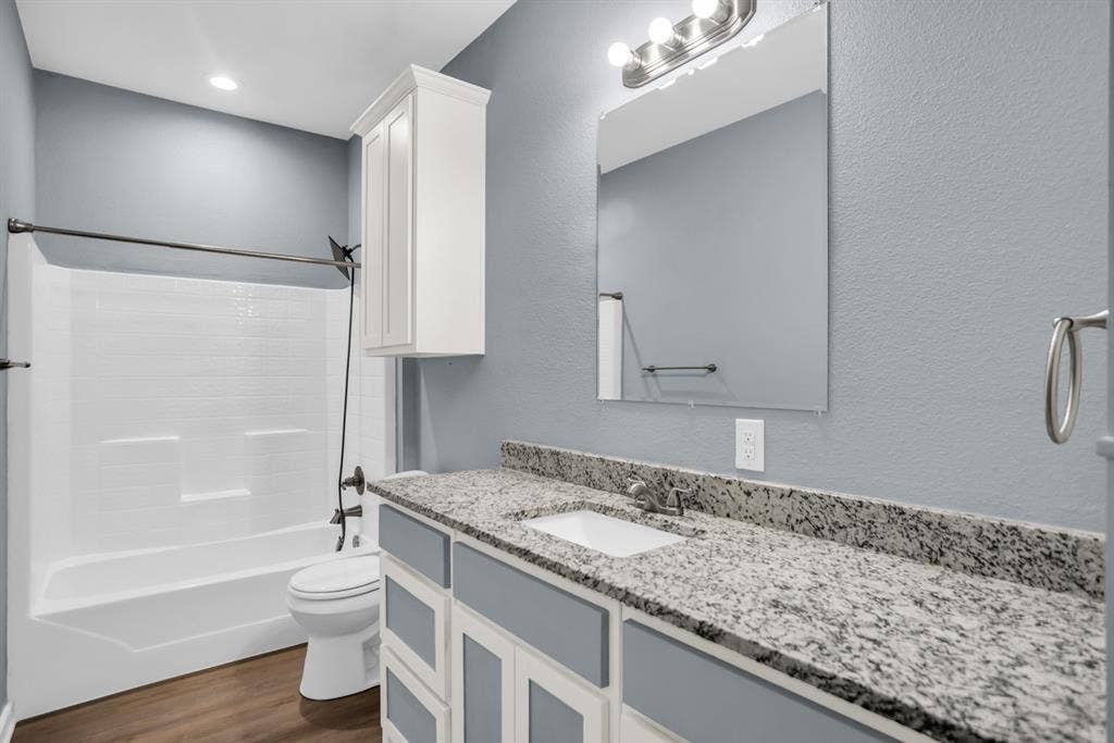 440 Pecan Hollow, Garrett, TX 75119 Bathroom featuring a spacious vanity with a granite countertop, undermount sink, and a framed mirror