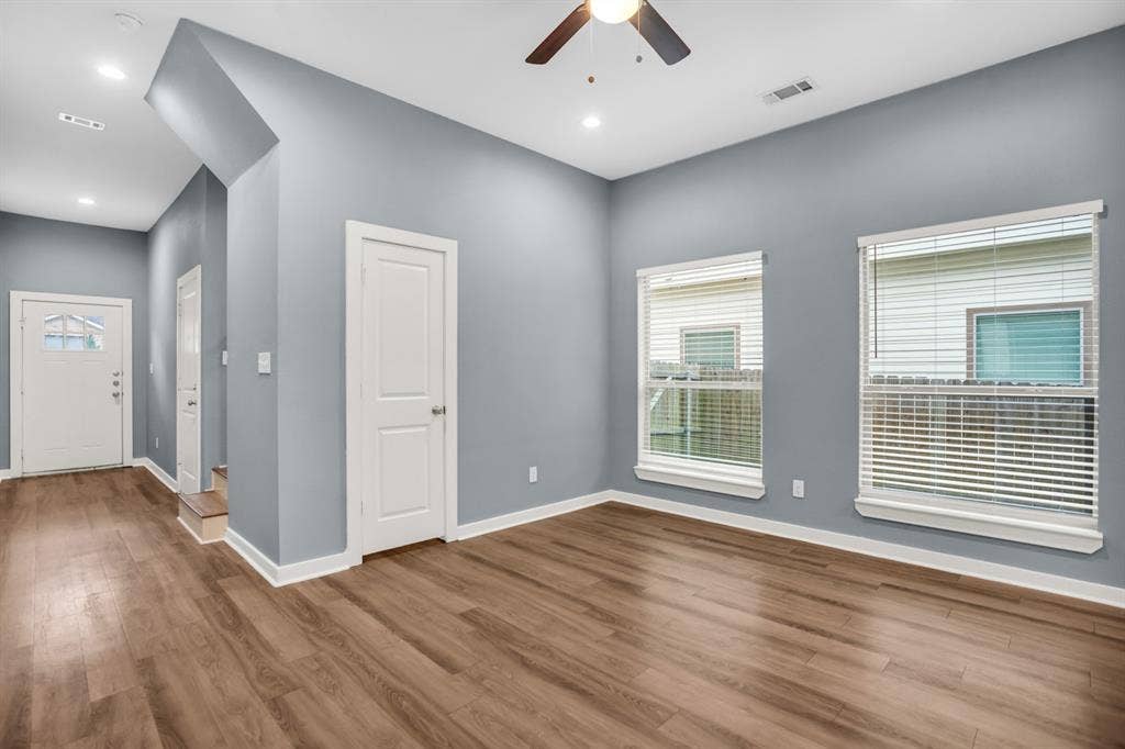 440 Pecan Hollow, Garrett, TX 75119 Spacious room with wood-finish flooring, light blue walls, and white trim