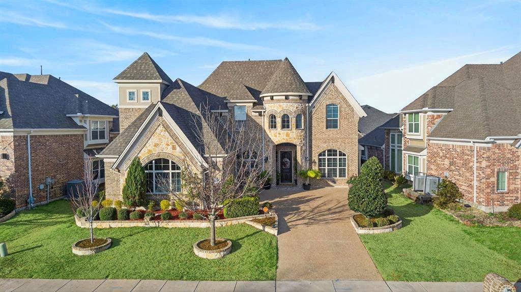 Brick and stone facade residence featuring multiple gables and turret architectural elements