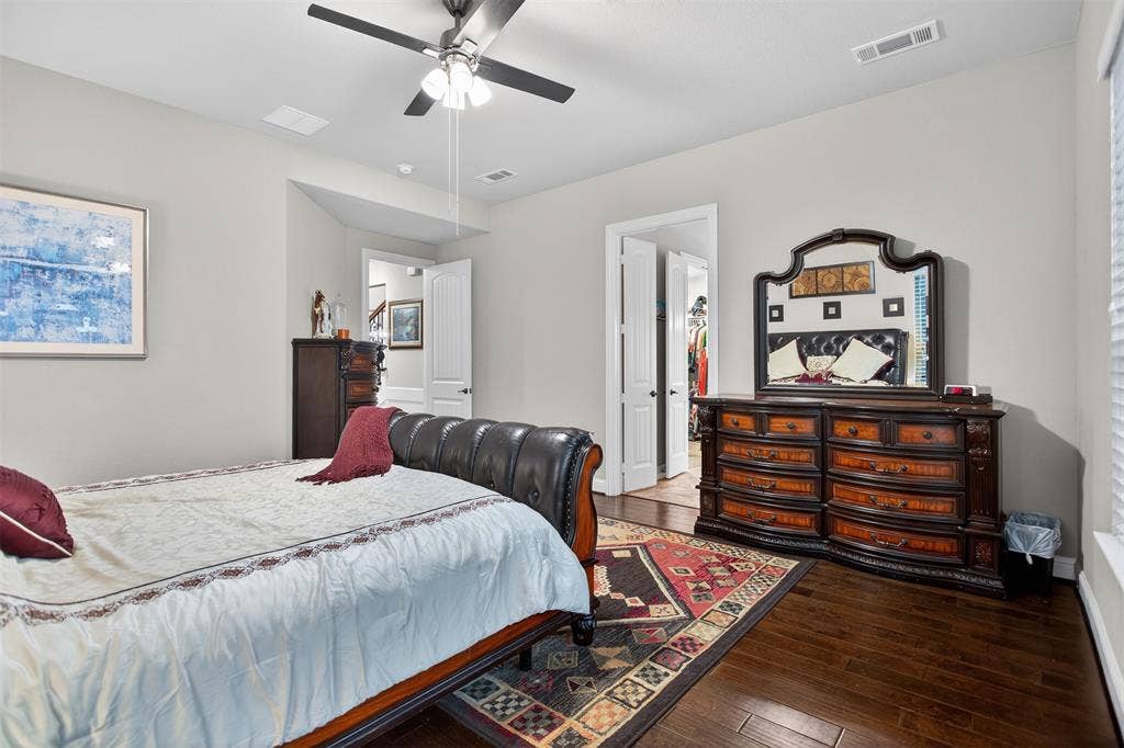 Hardwood-finish flooring, ceiling fan with integrated lighting, window with blinds, and white interior doors