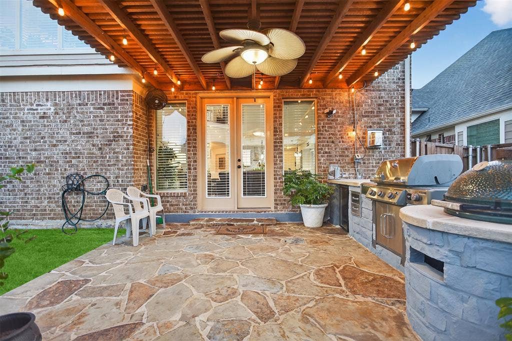 Covered patio with a wood slatted ceiling, a ceiling fan, and string lighting