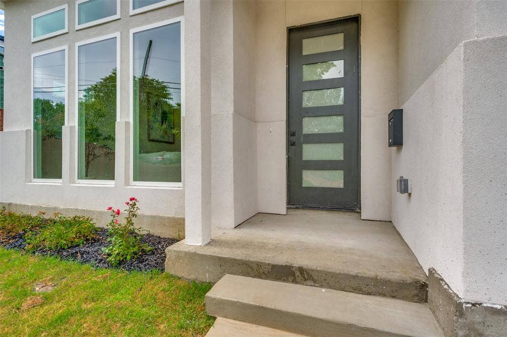 1511 Morrell Avenue, Dallas, TX 75203 Stucco exterior with multiple vertical windows and a contemporary front door featuring frosted glass panels