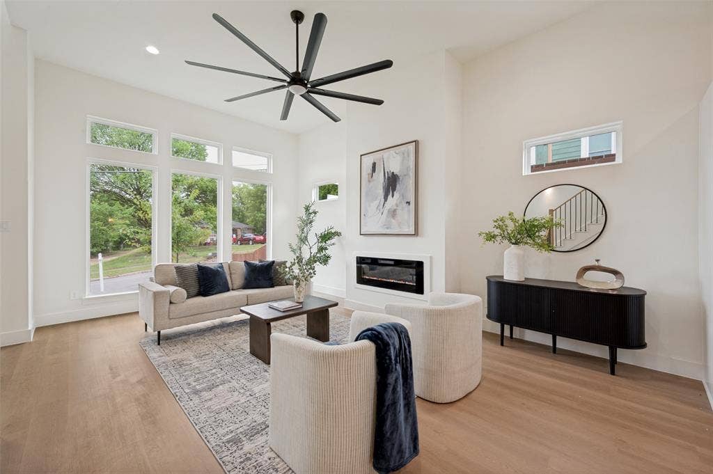 1511 Morrell Avenue, Dallas, TX 75203 Vaulted ceilings, wood-finish flooring, large multi-pane windows, a linear electric fireplace, and a contemporary ceiling fan