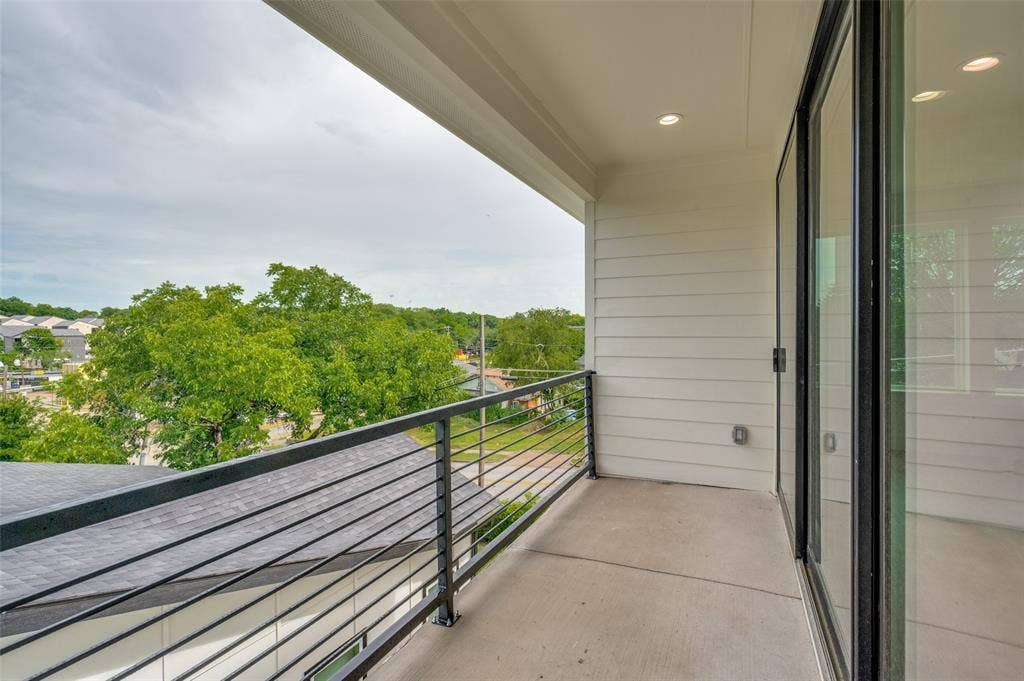 1511 Morrell Avenue, Dallas, TX 75203 Private balcony featuring a concrete floor, black metal railing, recessed lighting, and expansive sliding glass doors