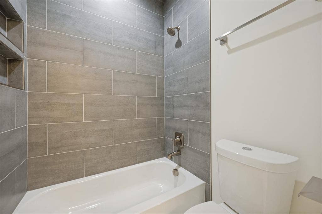 1511 Morrell Avenue, Dallas, TX 75203 Bathtub with integrated shower, subway tile surround, recessed shower niche, and brushed nickel fixtures