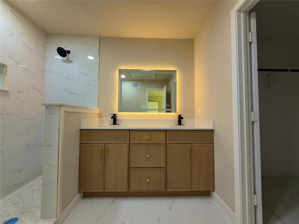 1834 Caldwell, Garland, TX 75041 Dual sink vanity with light wood-finish cabinetry and quartz countertop