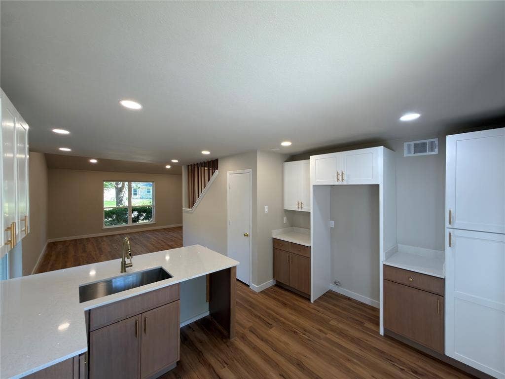 1834 Caldwell, Garland, TX 75041 Kitchen featuring white upper cabinetry, wood-finish lower cabinetry, white countertops, and a stainless steel sink with a gooseneck faucet