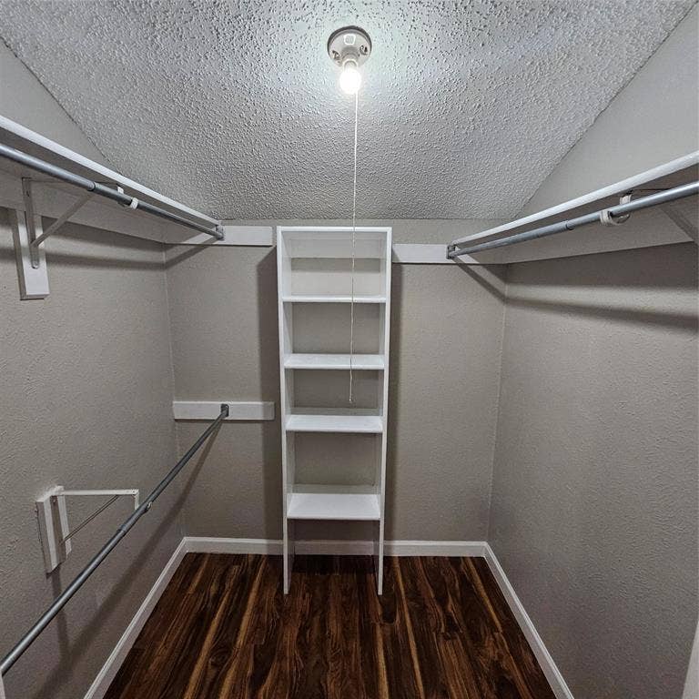 9600 ROYAL, #612, Dallas, TX 75243 Walk in closet featuring wood finished floors and lofted ceiling