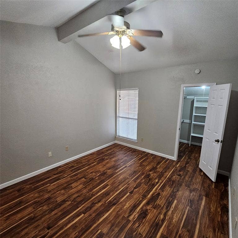 9600 ROYAL, #612, Dallas, TX 75243 Unfurnished bedroom featuring dark wood-style floors, a walk in closet, a closet, and ceiling fan