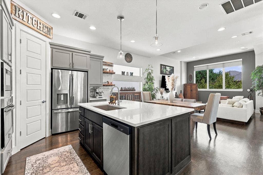 Stainless steel appliances flank the walk-in pantry with coffee bar and wine fridge off to the side.
