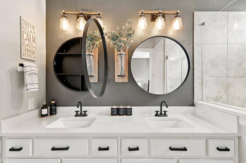 This primary bathroom has decorator upgrades with mirrored cabinets for additional storage.