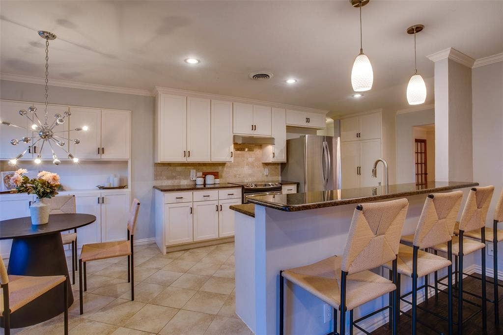 3918 Royal Palms Court, Dallas, TX 75244 Custom Kitchen with expansive barstool counter, generous cabinetry and stainless appliances.