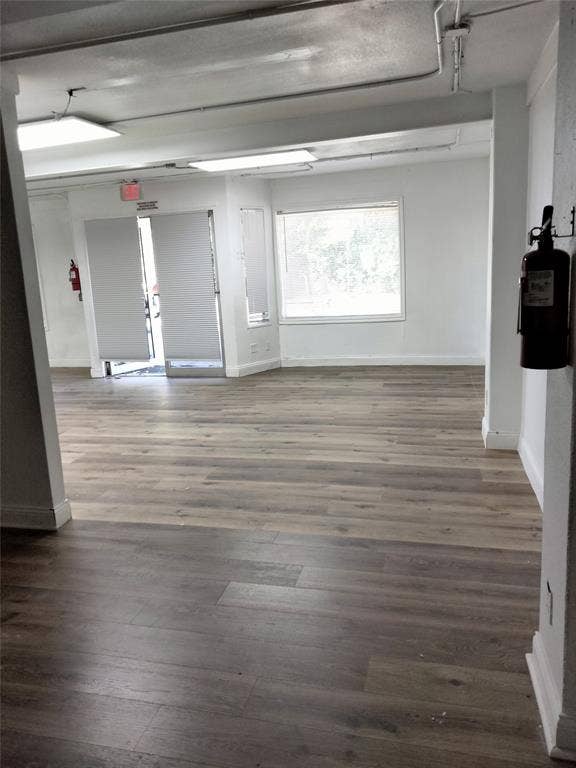 513 N 4th Street, Princeton, TX 75407 Spacious interior with wood-finish flooring, white walls, and track lighting