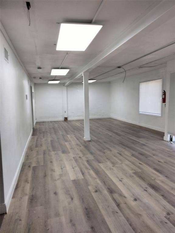 513 N 4th Street, Princeton, TX 75407 Spacious interior with wood-finish flooring, white walls, and multiple rectangular ceiling light fixtures