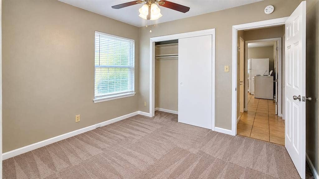 914 Harlandale Avenue, Dallas, TX 75216 Carpeted room with a window, white trim, and a ceiling fan