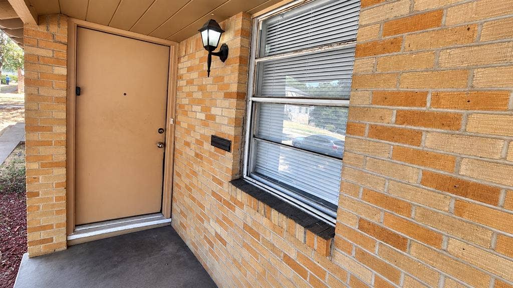 914 Harlandale Avenue, Dallas, TX 75216 Brick exterior with an entryway sconce and a front window