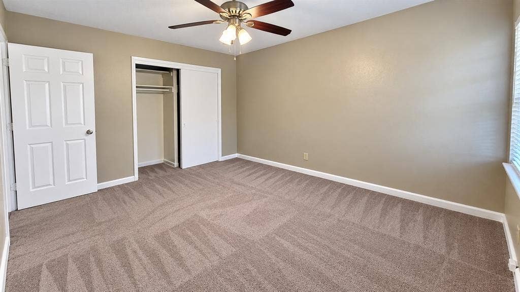 914 Harlandale Avenue, Dallas, TX 75216 Neutral-toned walls, patterned carpet, white trim, and a ceiling fan with integrated lighting