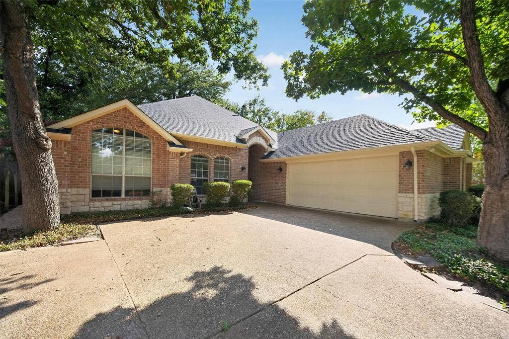 1102 Hartman Court, Arlington, TX 76006 Brick exterior with stone accents, a gabled roofline, and an attached two-car garage