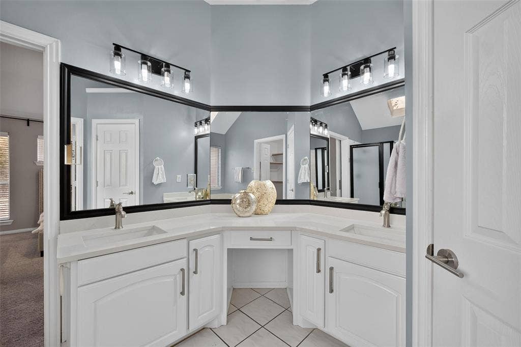 1102 Hartman Court, Arlington, TX 76006 Dual vanity with integrated sinks, quartz-finish countertops, built-in makeup area, and tile flooring